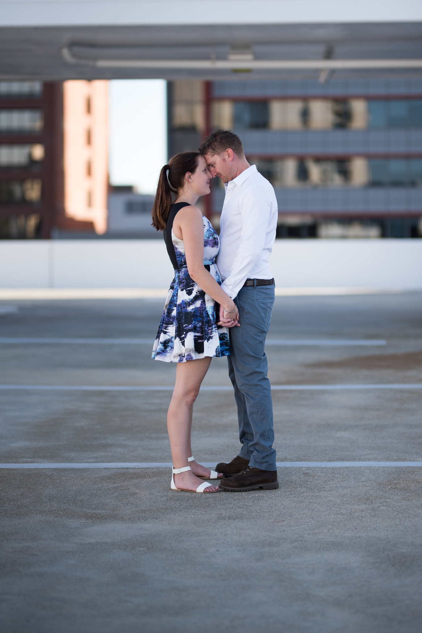 Boy and girl holding hands on carpark rooftop