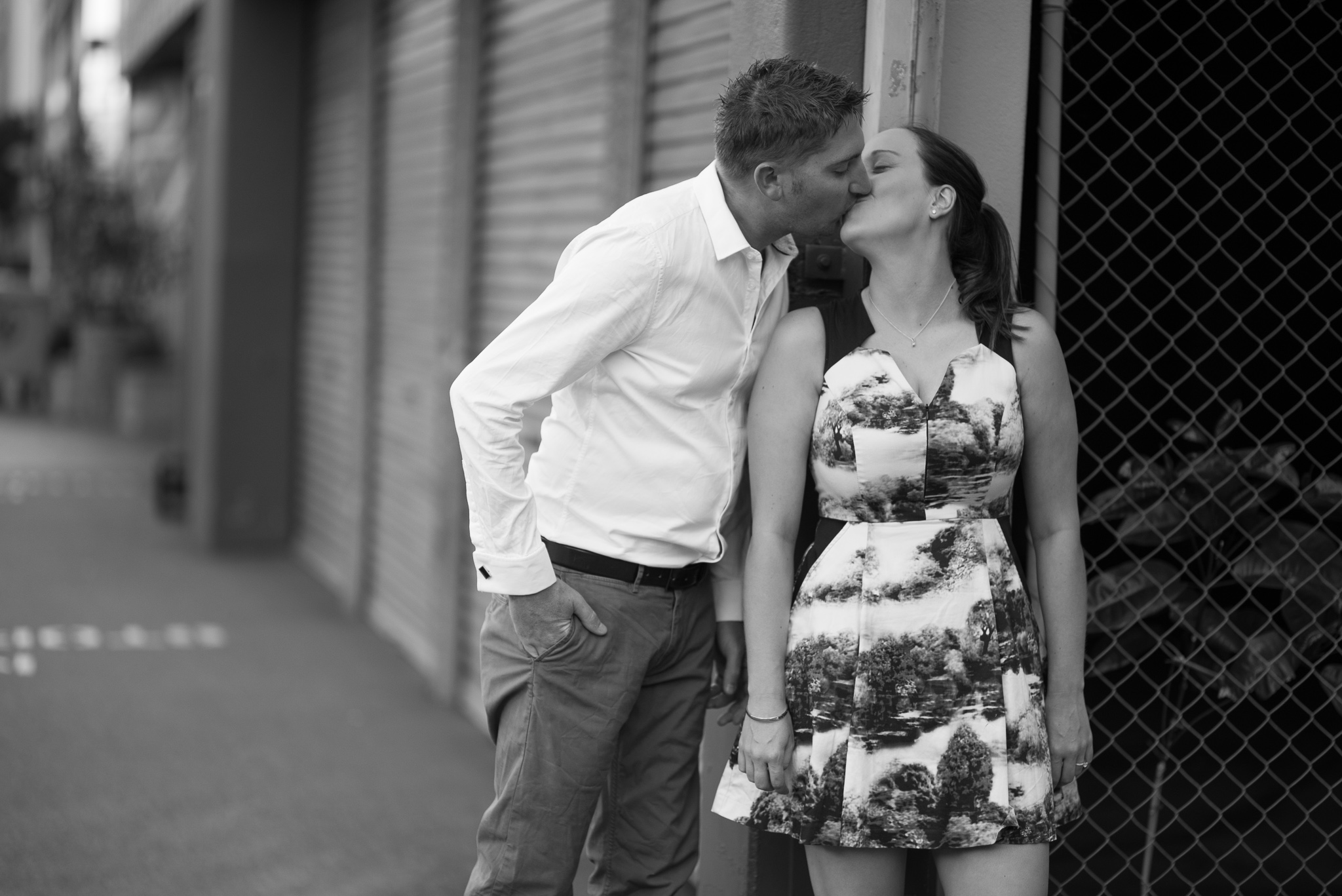 Girl and her fiancee kissing in Wolf Lane in black and white