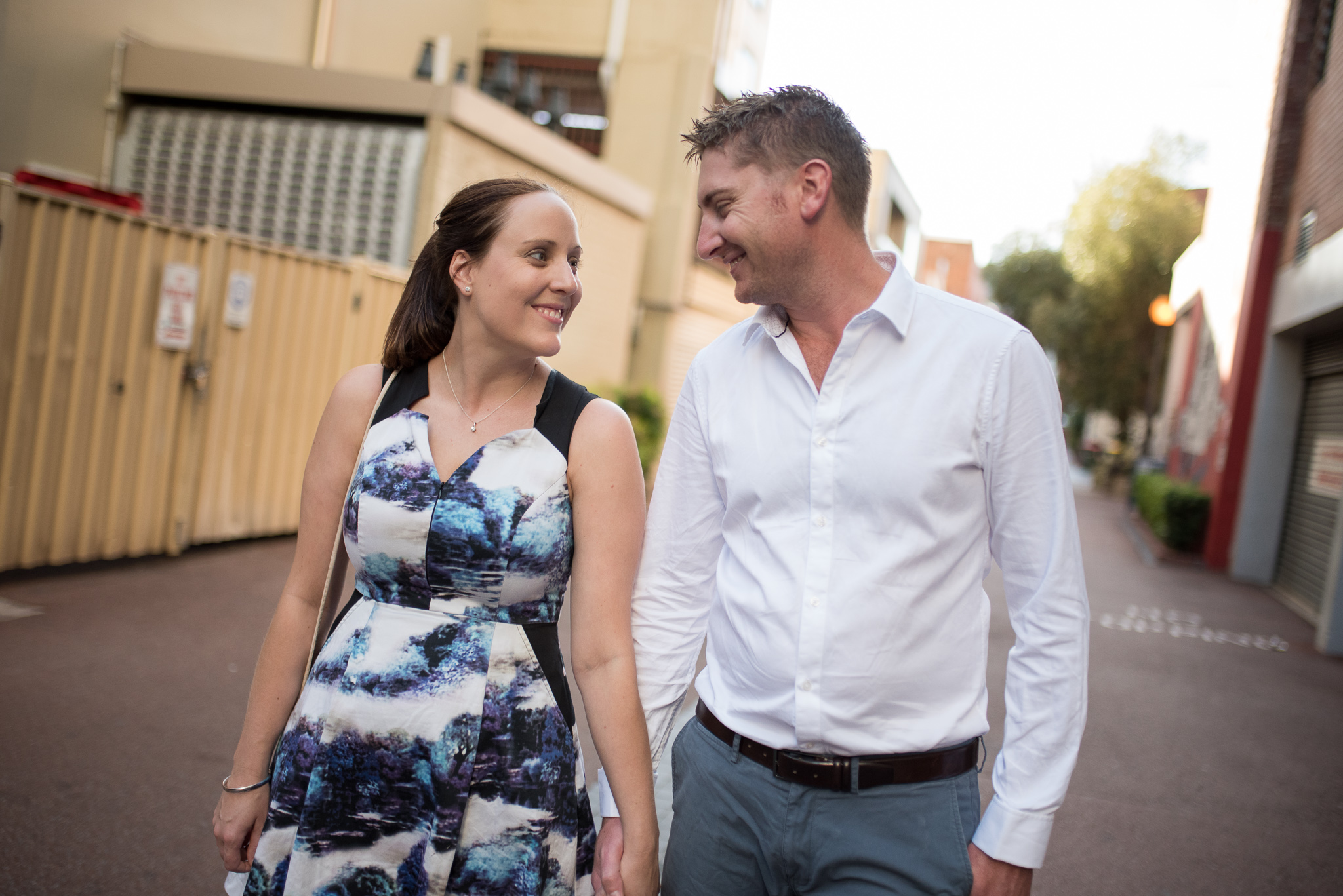 Happy engaged couple grinning walking down Wolf Lane