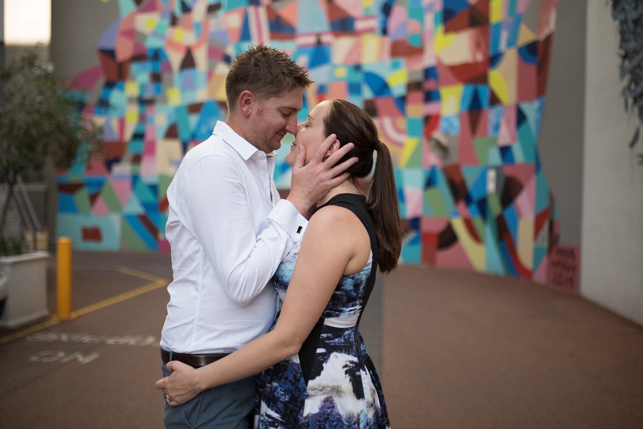 Engaged couple at Wolf Lane with Maya Hayuk mural behind