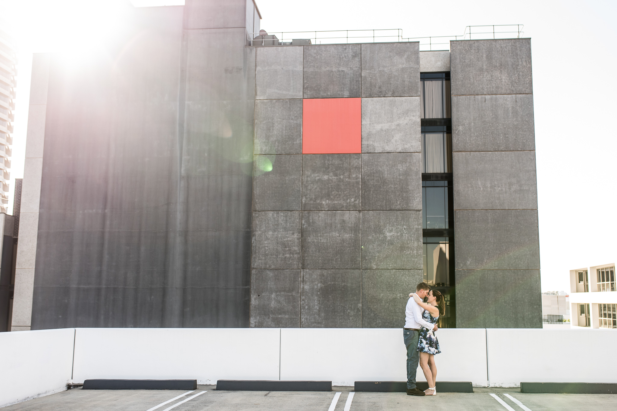 Red square on Perth city building with engaged couple on carpark roof top