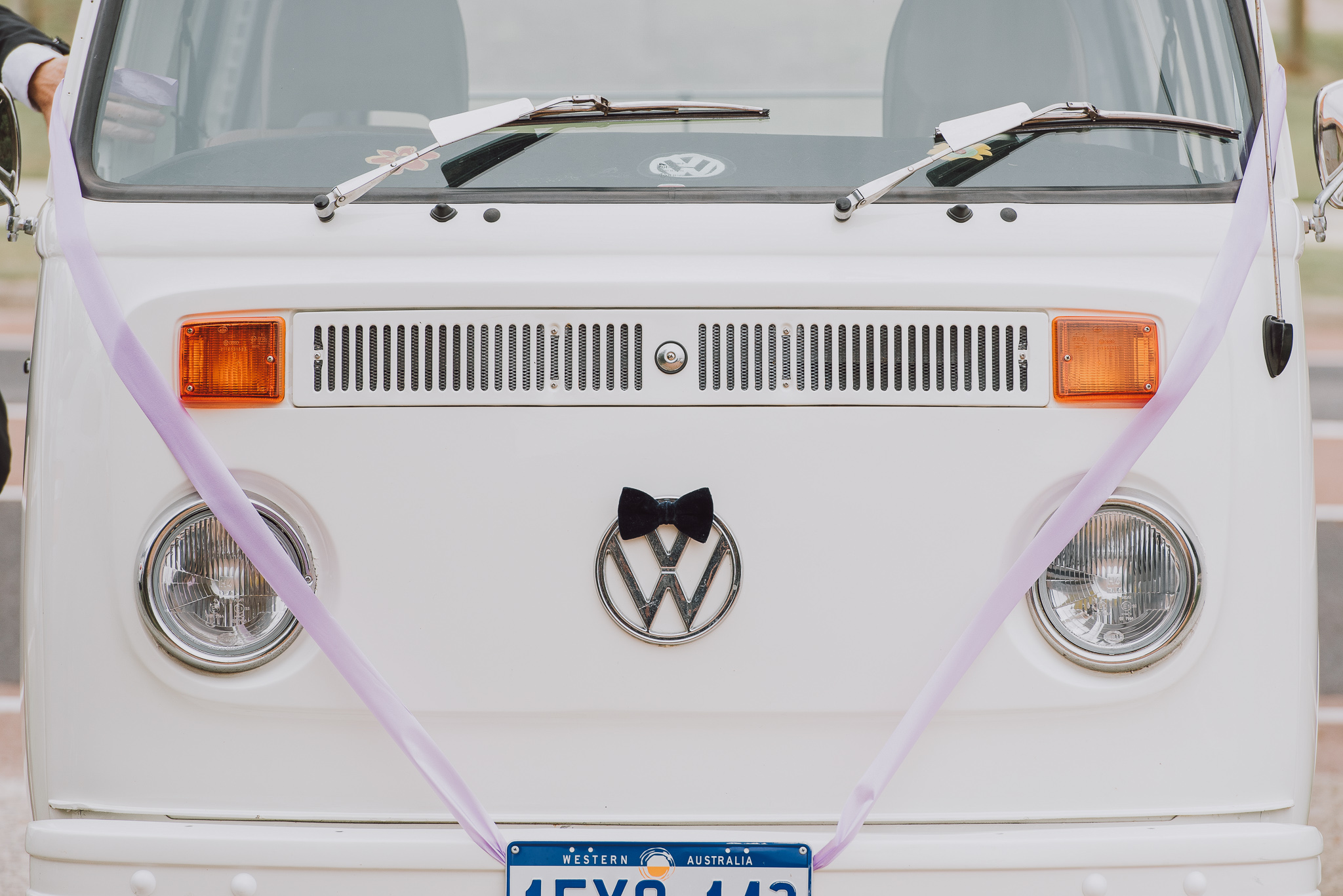 close up of front of Kombi van with wedding ribbon and bow tie