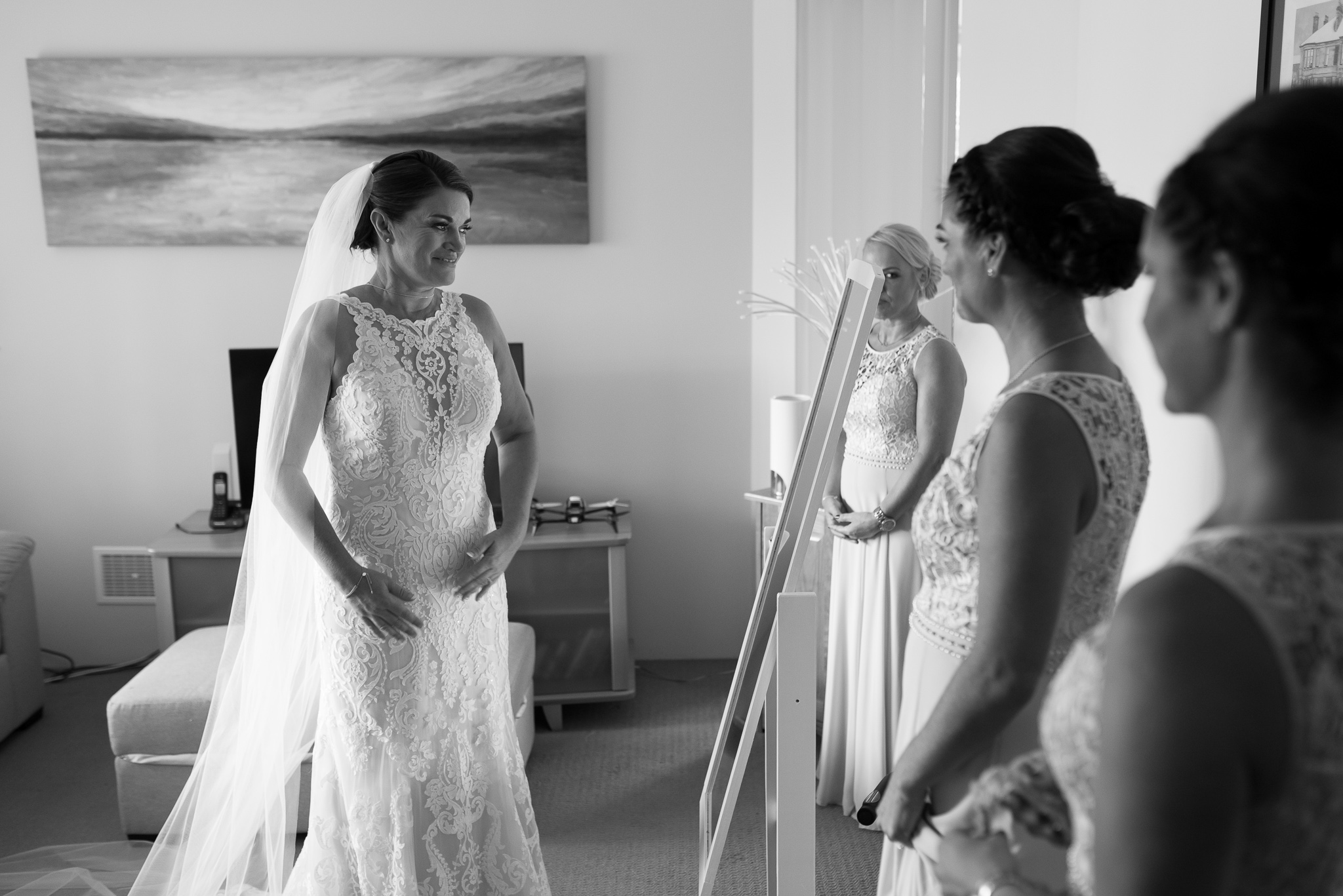 bride smiles looking at herself in the morror