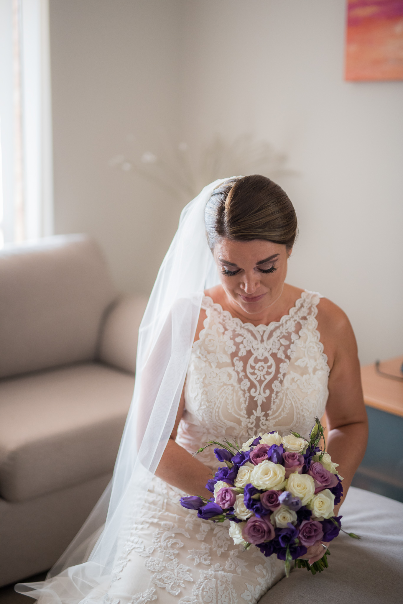 bride looks down at her bouquet sitting on her lounge