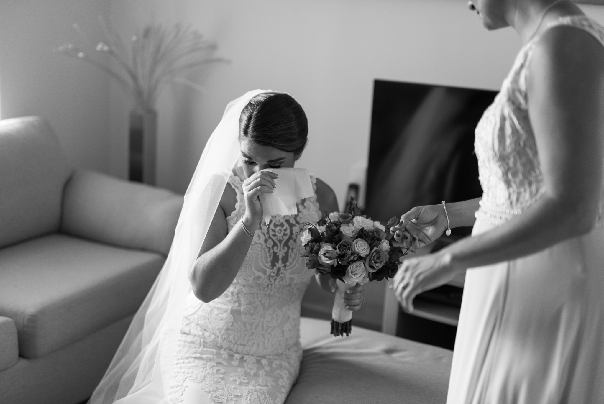 bride dabs tears from her eyes getting ready