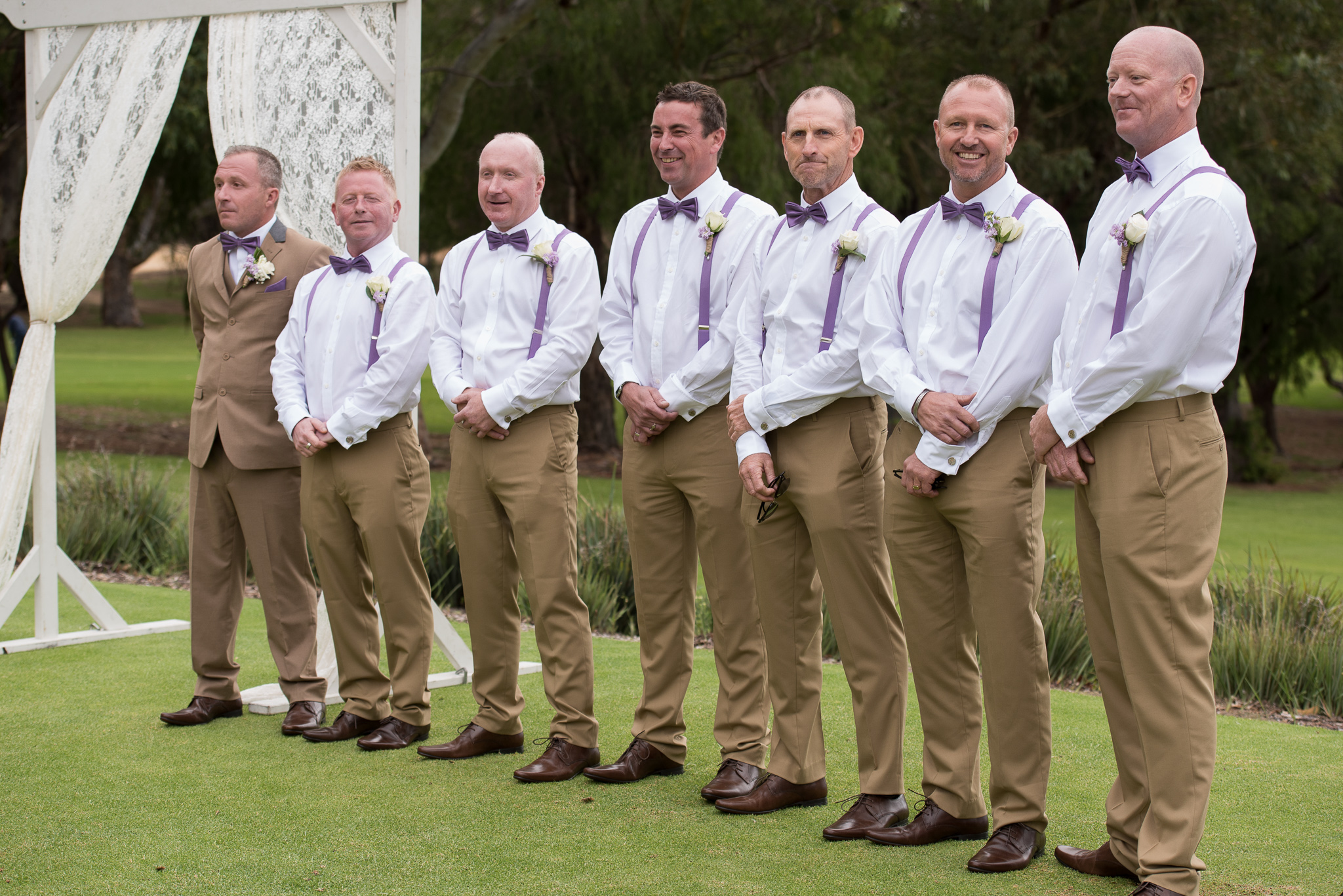 groom waits for ceremony to begin with six groomsmen