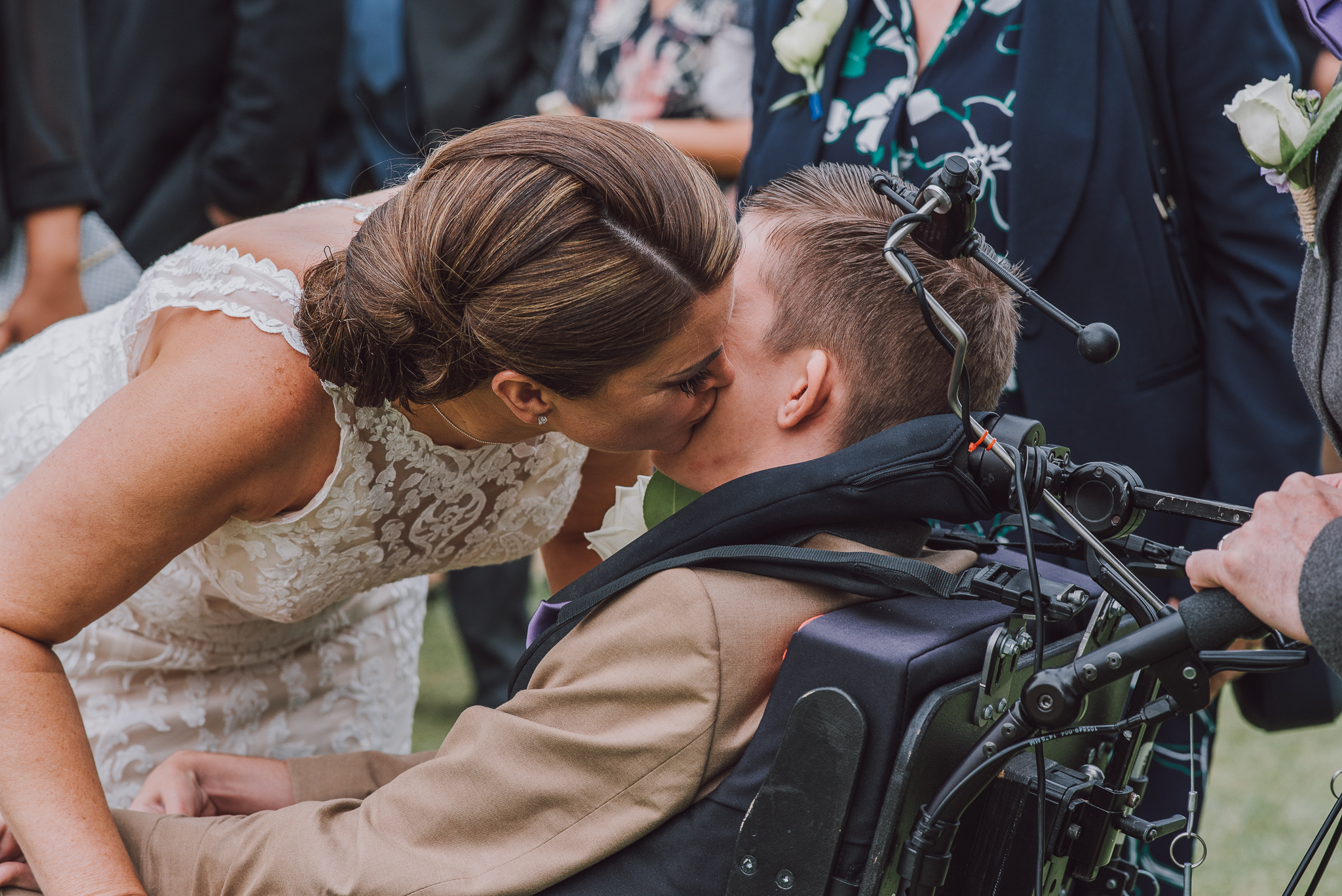 bride kisses her son in a wheelchair