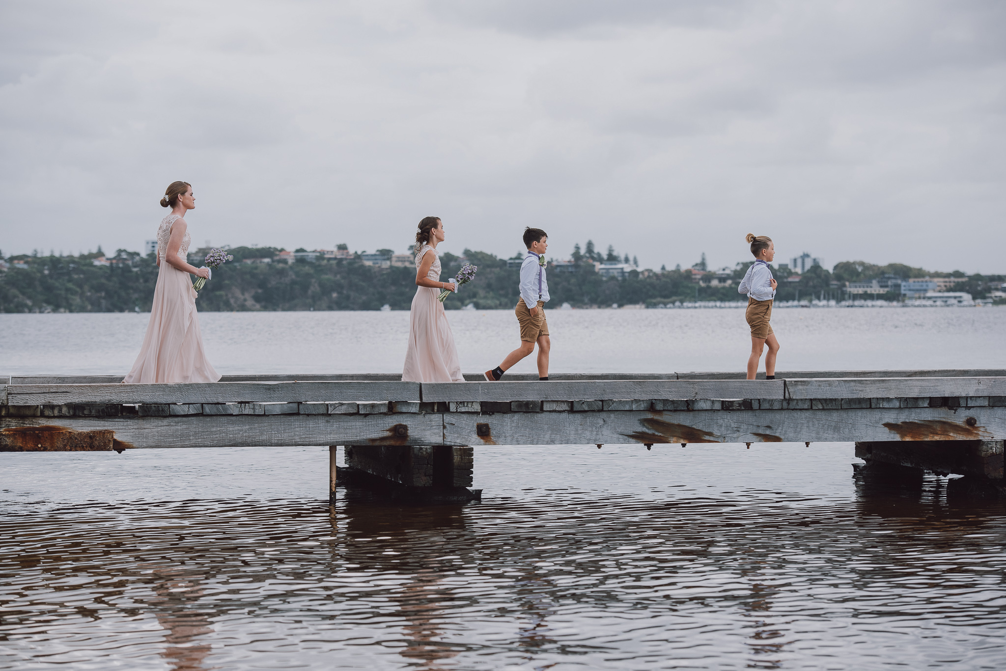 junior bridal party walking along pier