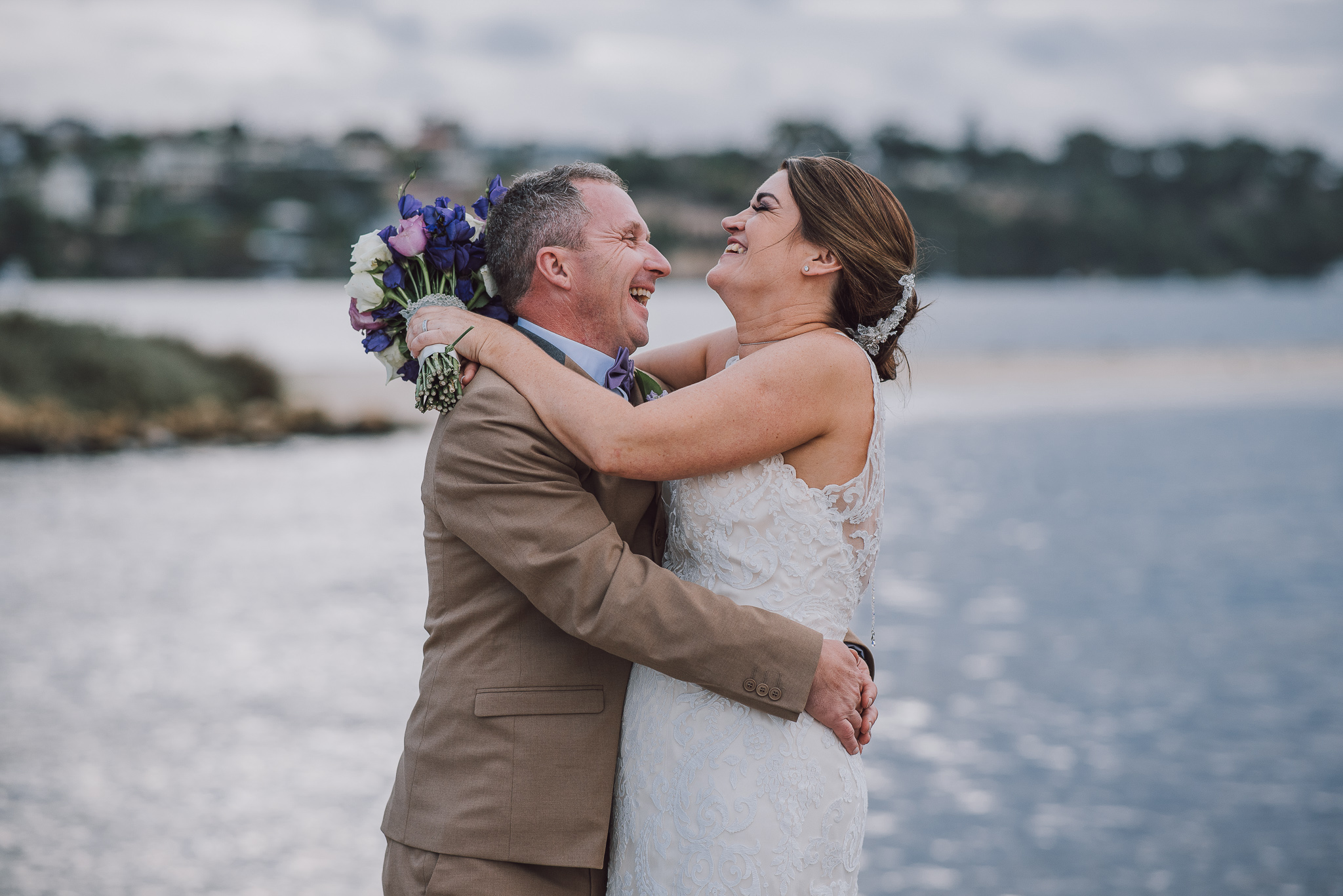 bride and groom cuddling and laughing