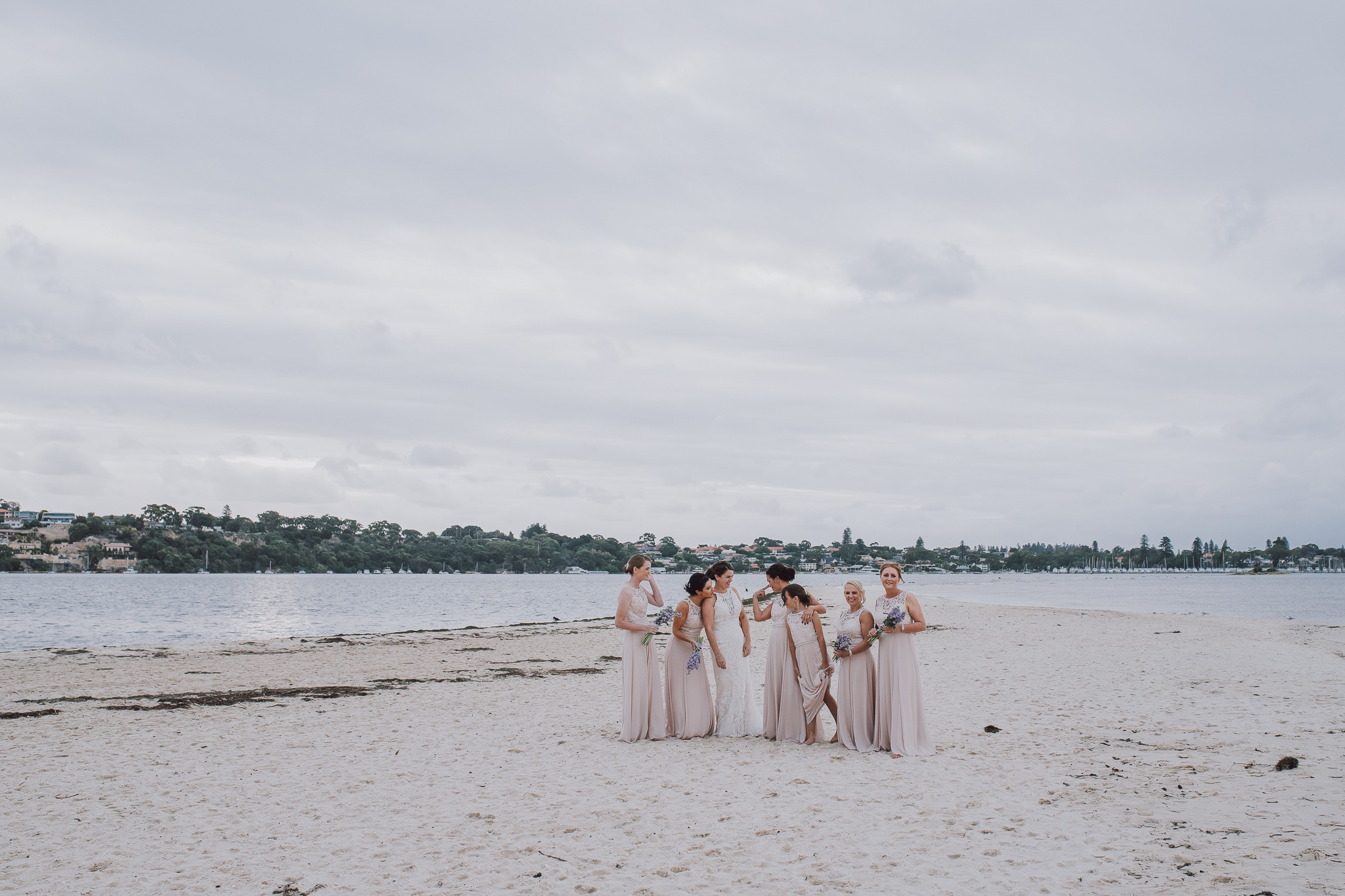 bridal party on the beach with grey skies