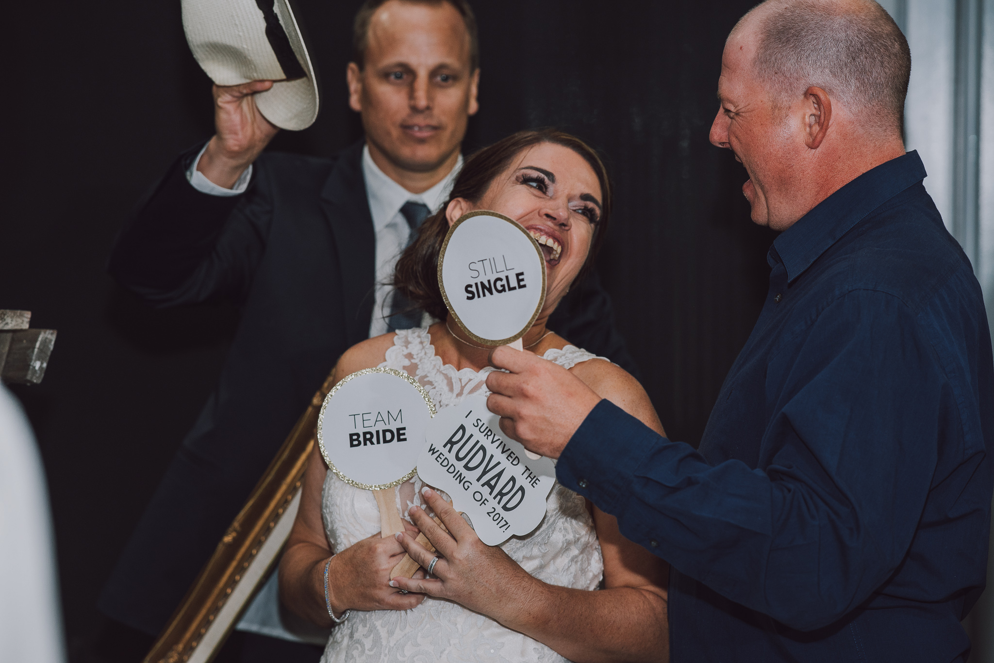 bride playing with photo booth props