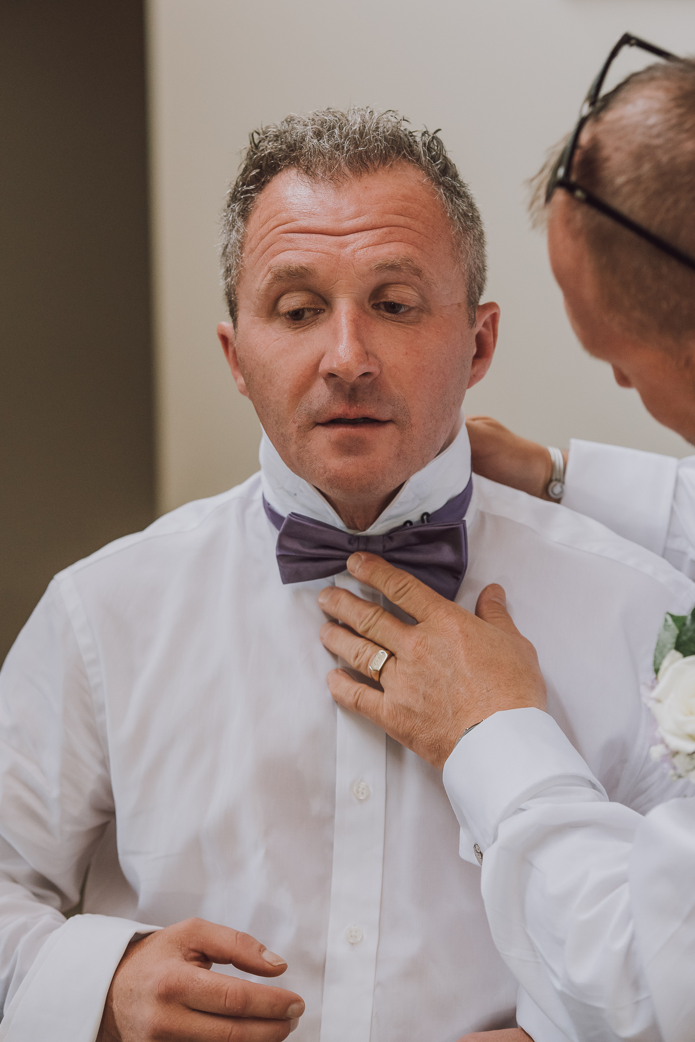 Groom has his bow tie adjusted