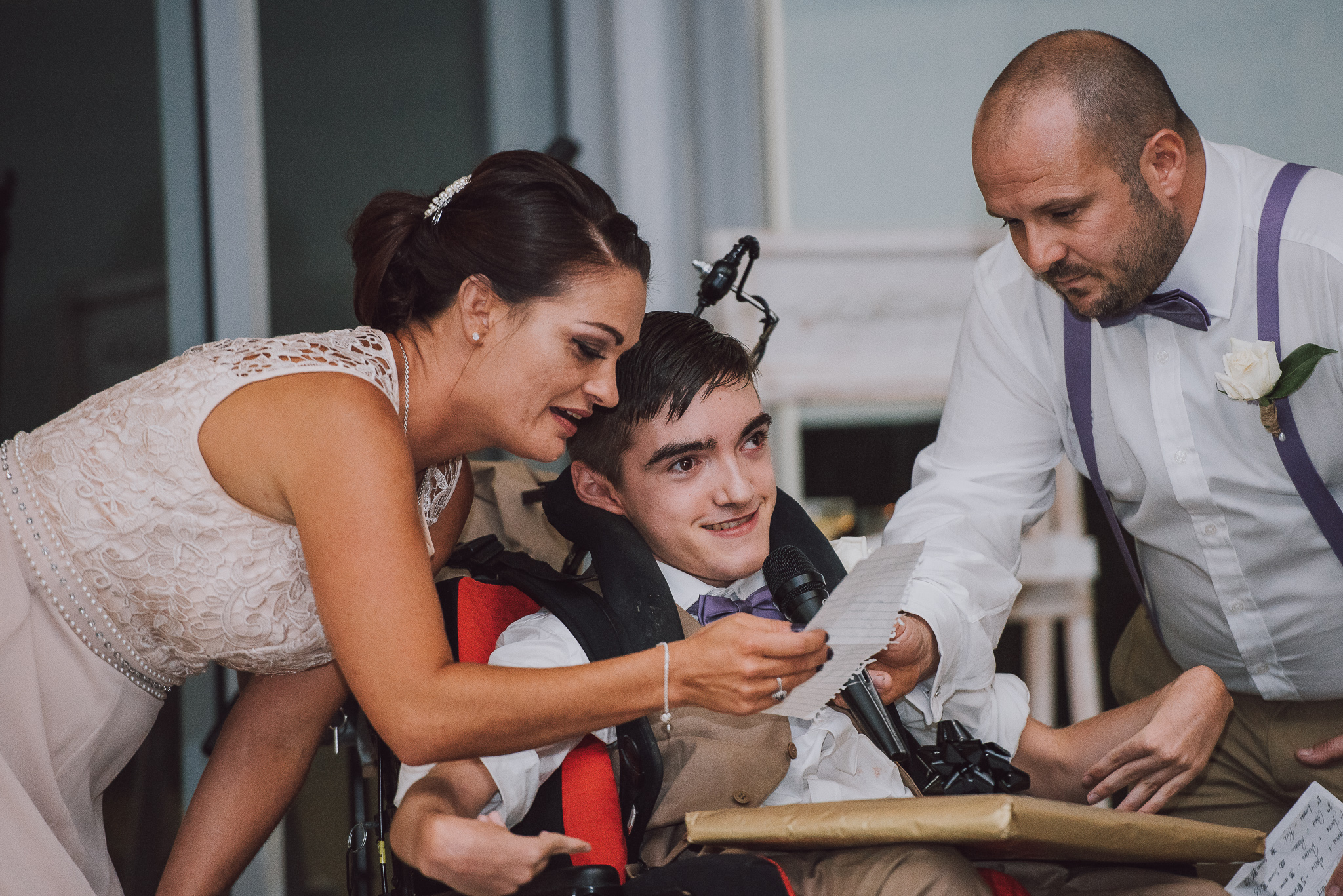 bridesmaid helps son in wheelchair to read his speech to his parents getting married