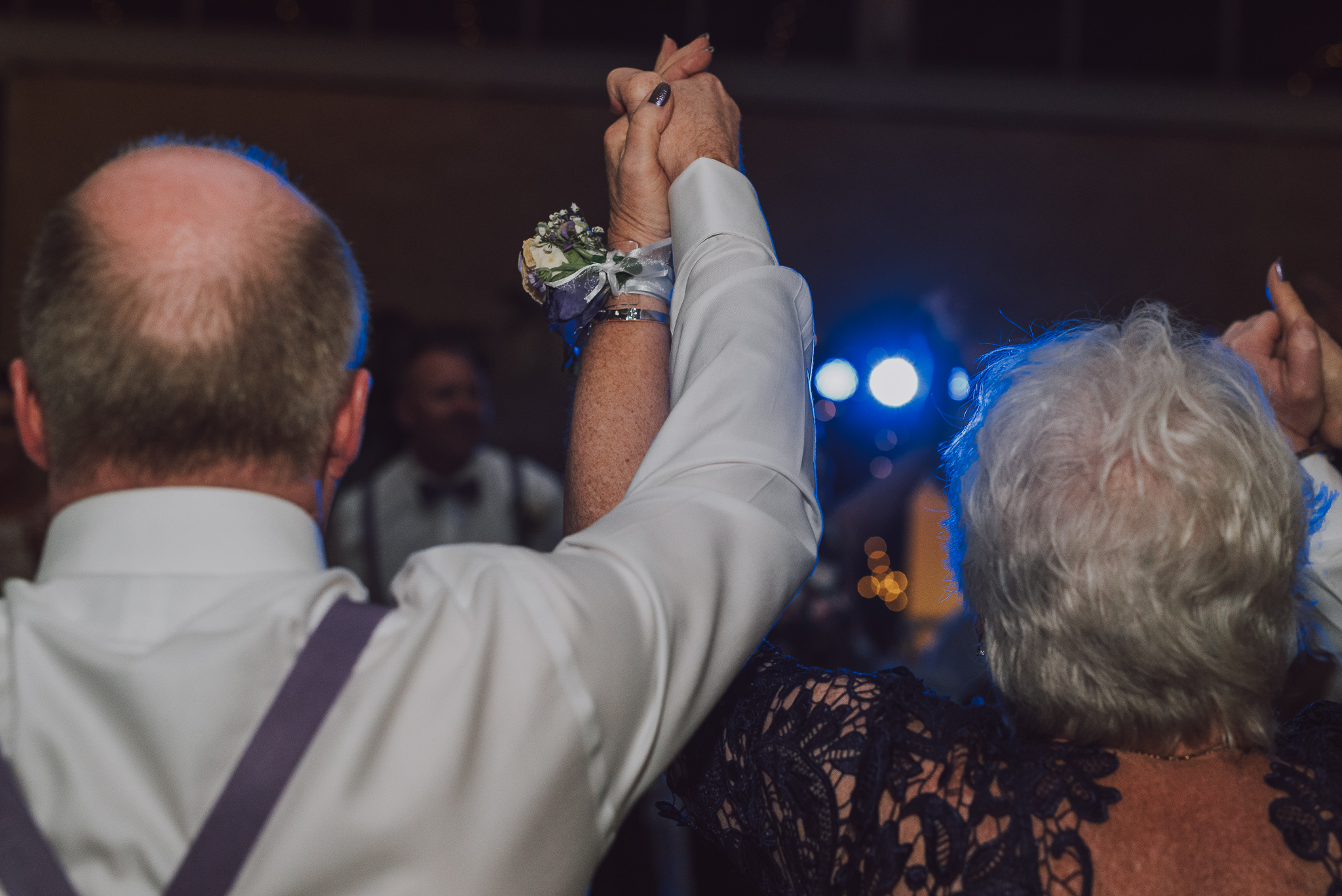 two older people holding hands on the dance floor