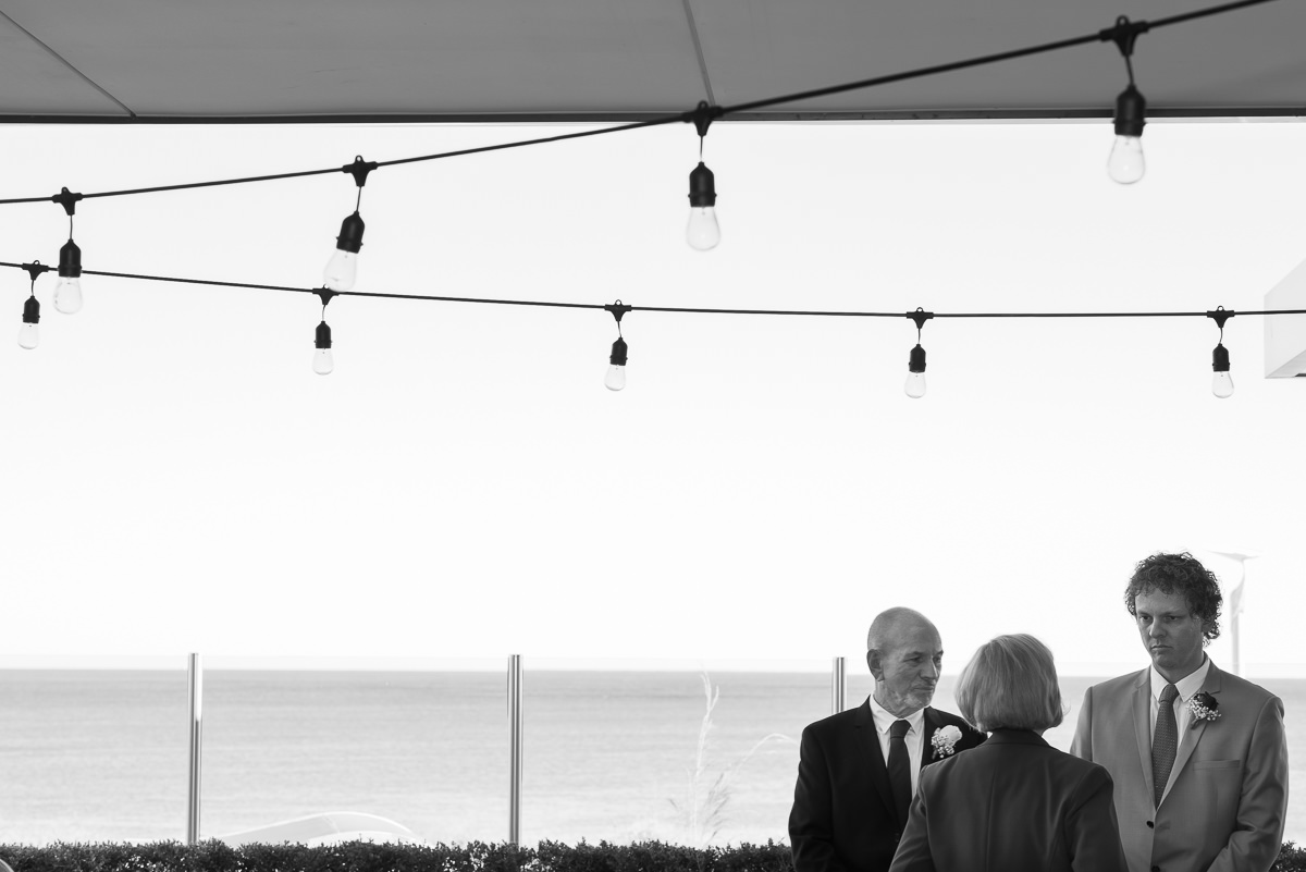 Black and white artistic photo of groom and son with celebrant at Portofinos