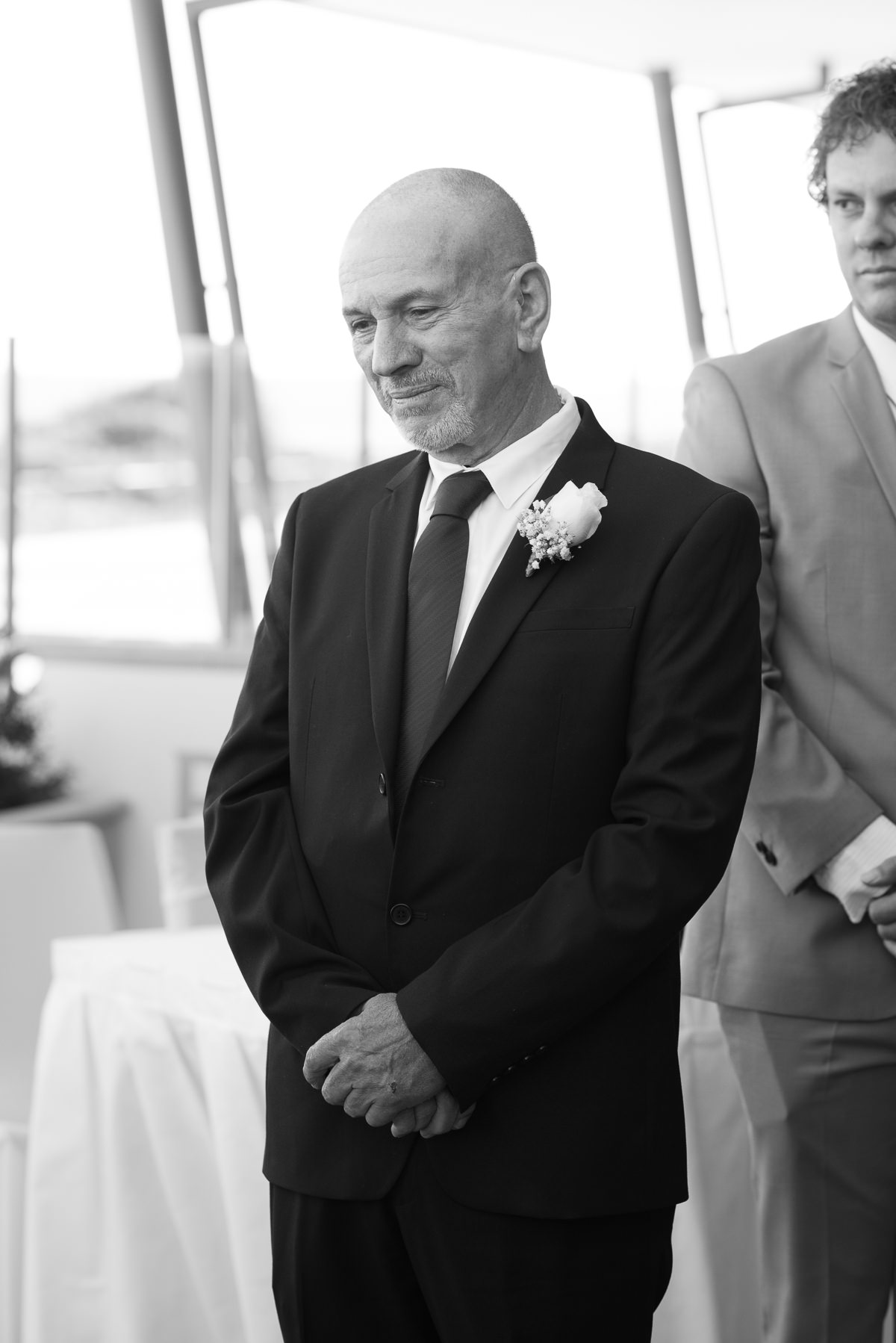 Black and white photo of groom at wedding