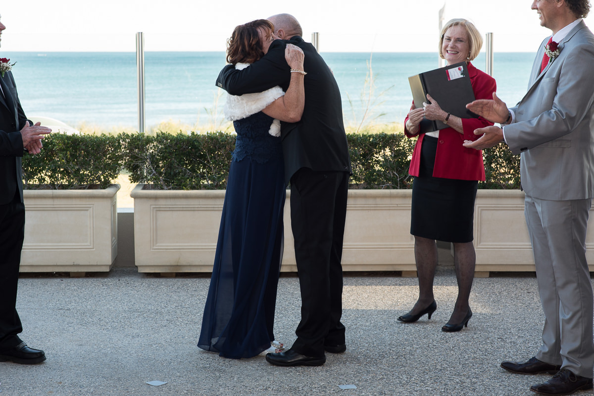 Mature aged wedding couple hugging during their ceremony