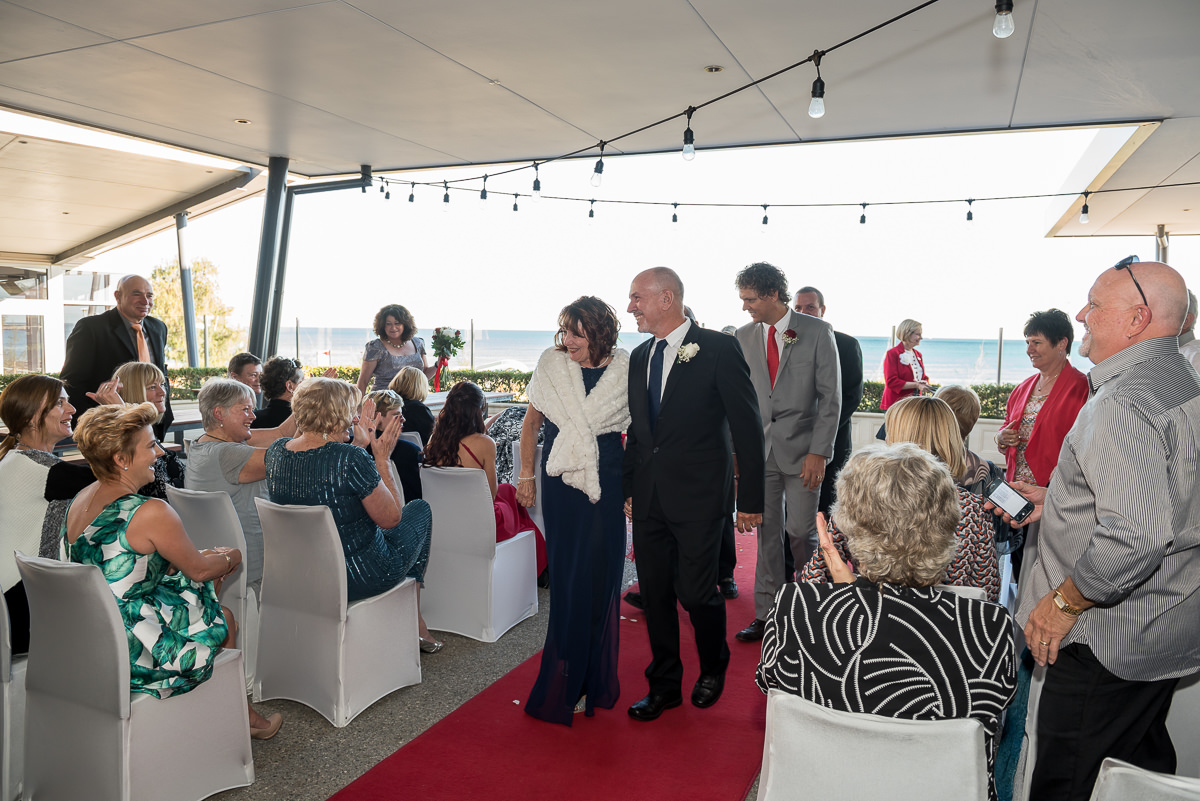 Older bride and groom walking down the aisle