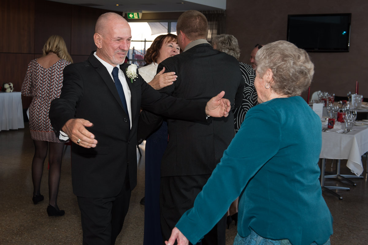 Groom embracing wedding guest