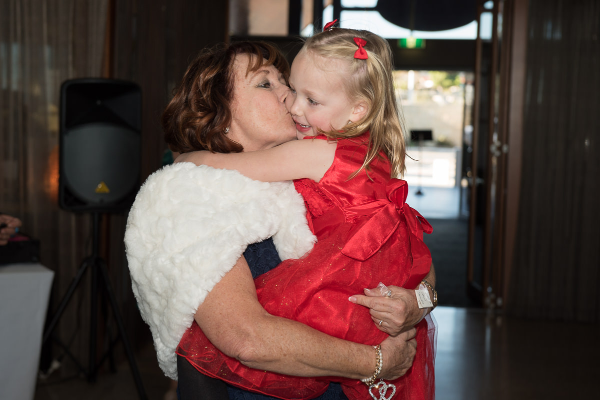 Mature aged bride kissing her granddaughter on the cheek