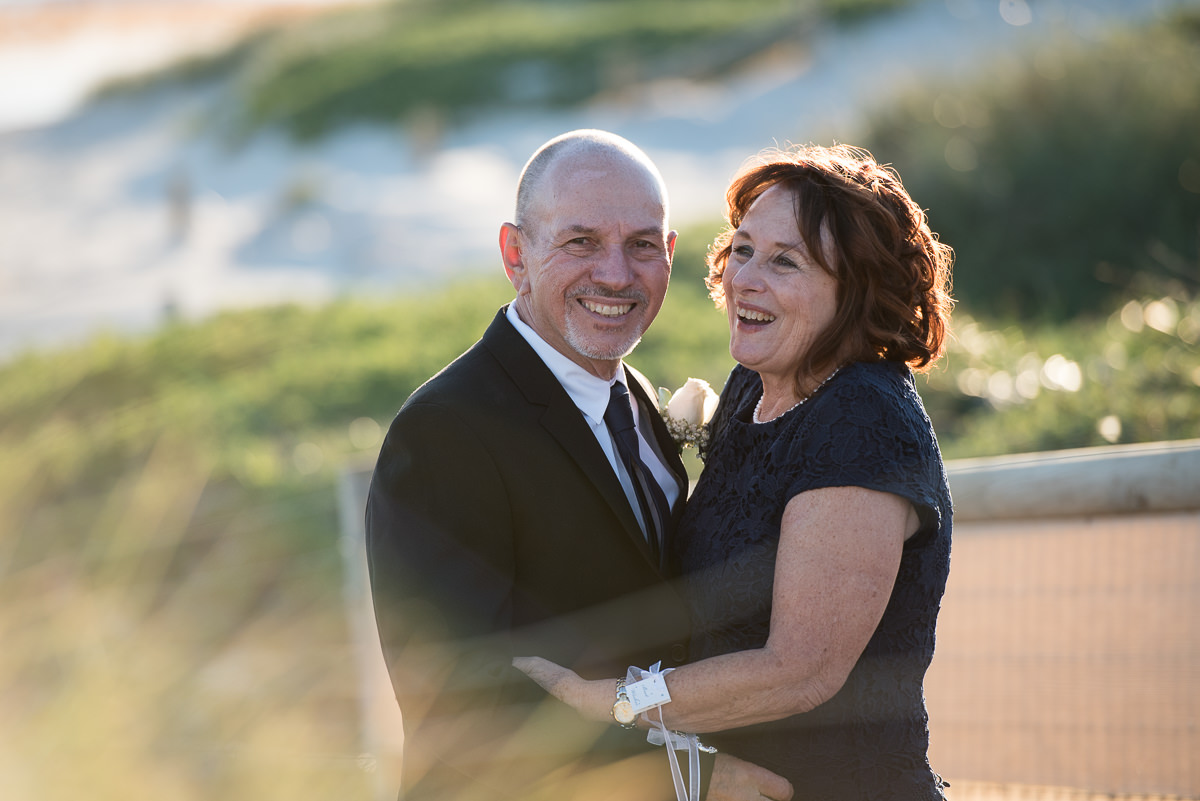 Happy portrait of older wedding couple laughing at the beach at Mindarie