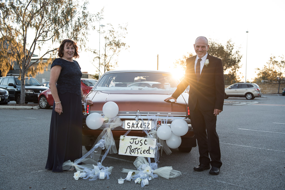 Older wedding couple with their old Holden wedding car