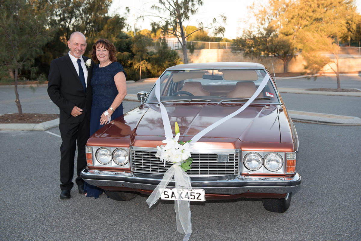 Older wedding car standing next to their old Holden car