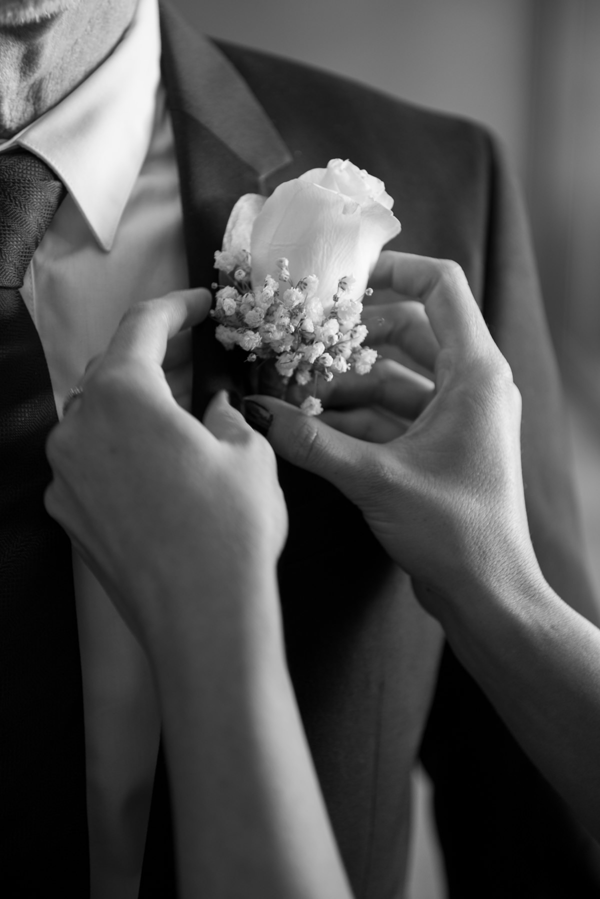 Putting buttonhole flower on the groom