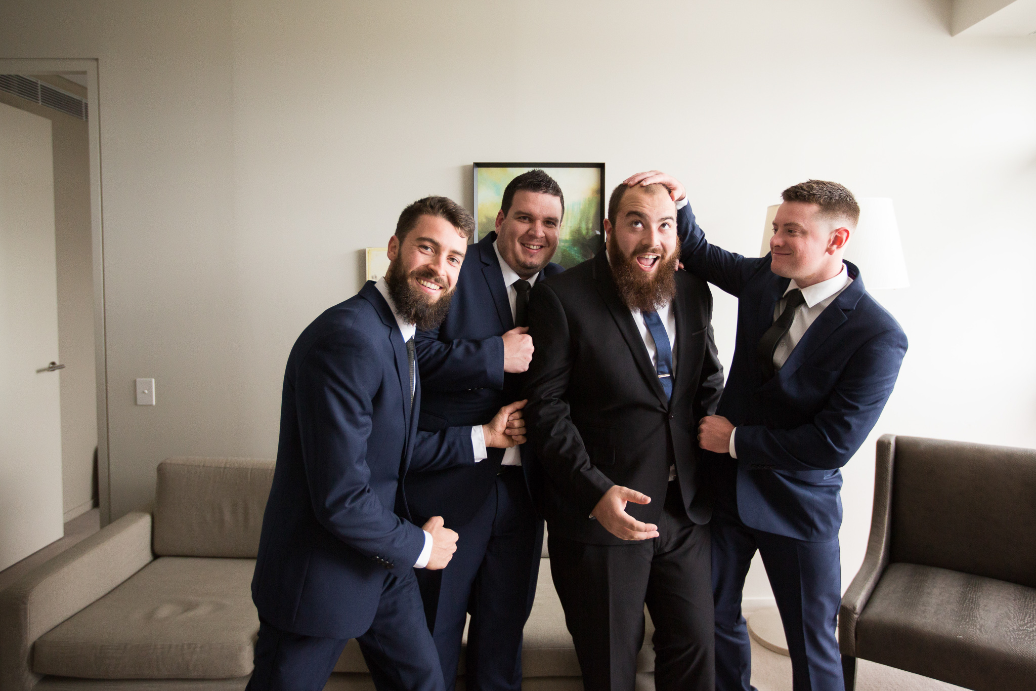 groom and groomsmen kidding around at their house getting ready