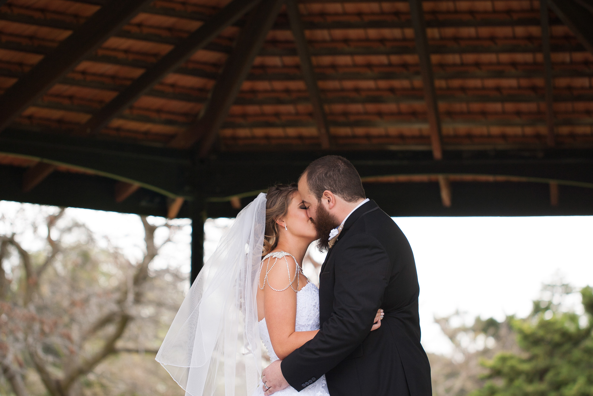 bride and groom kiss during wedding ceremony at queens gardens