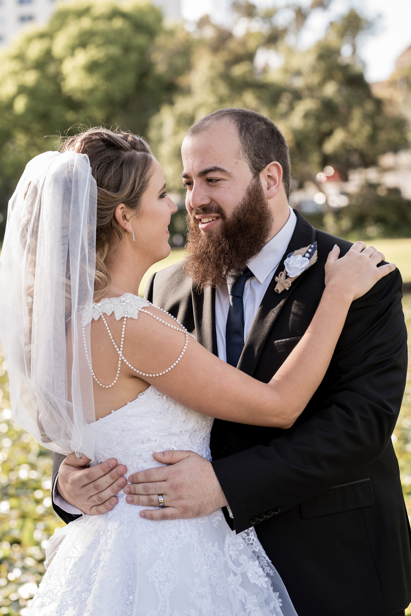 bride and groom holding each other and smiling at each other