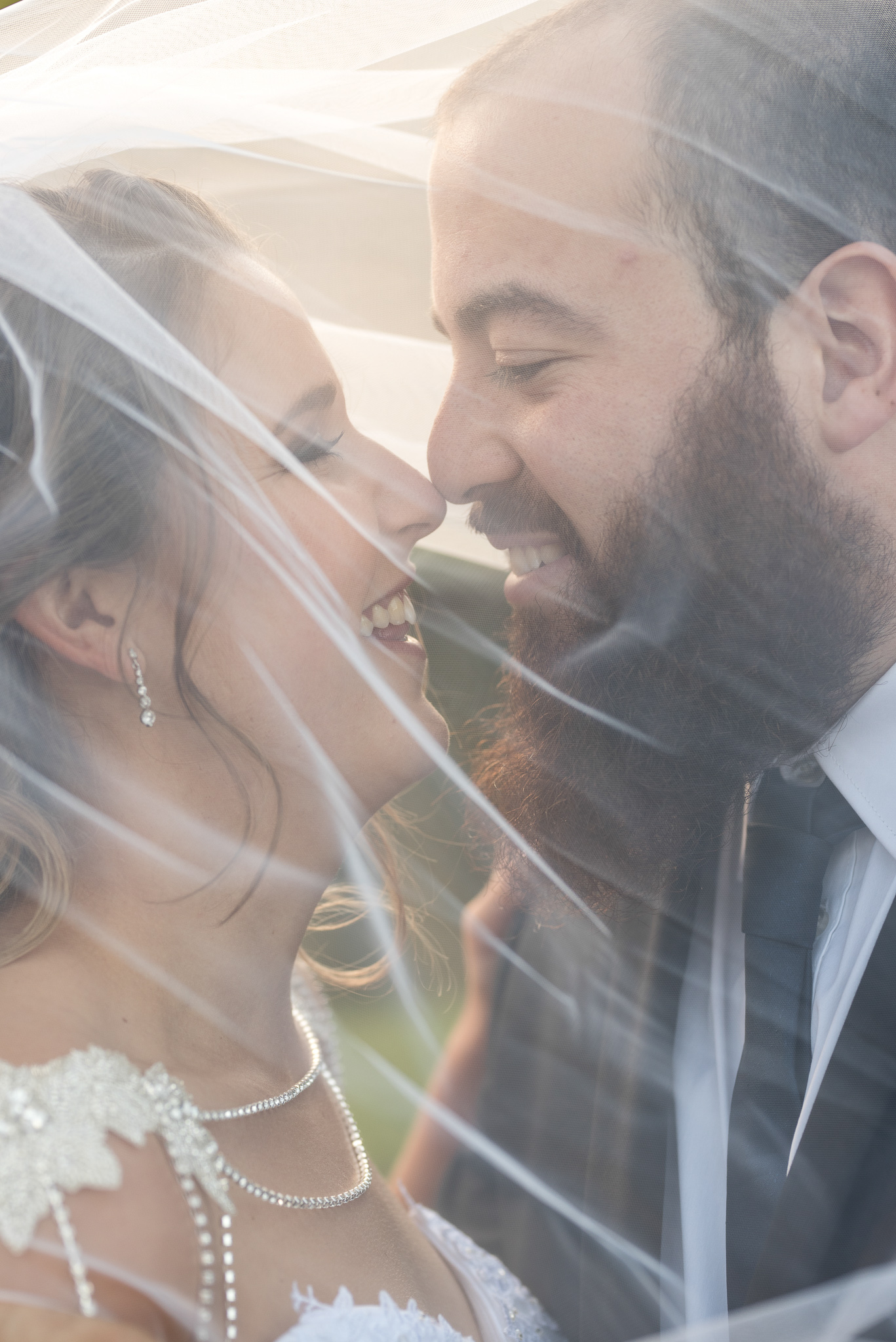 bride and groom's faces close under veil