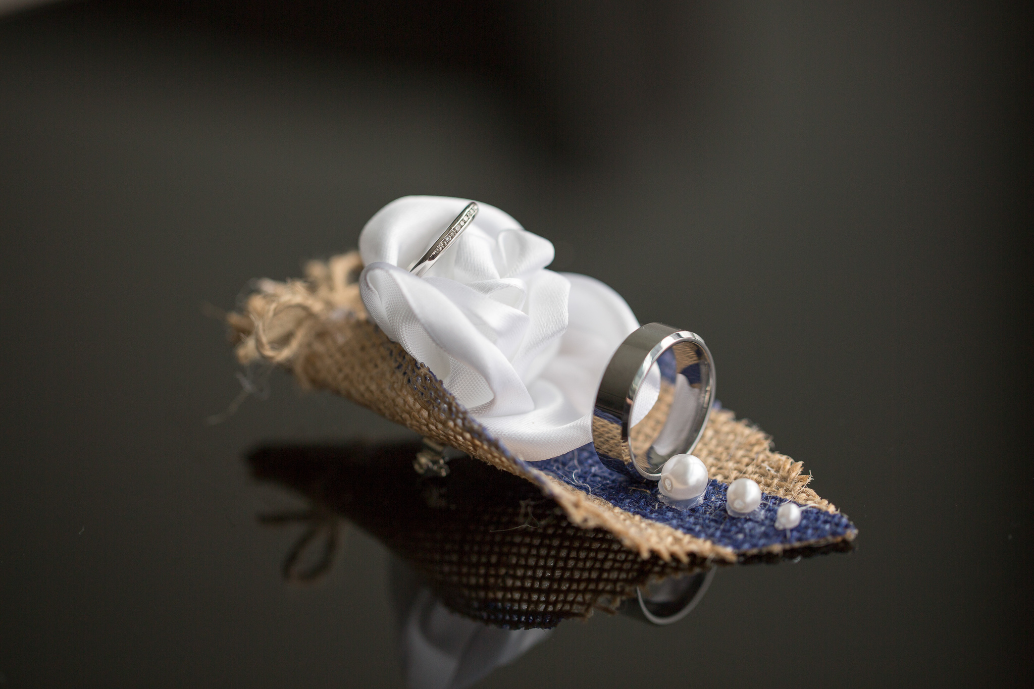 closeup of wedding rings and buttonhole