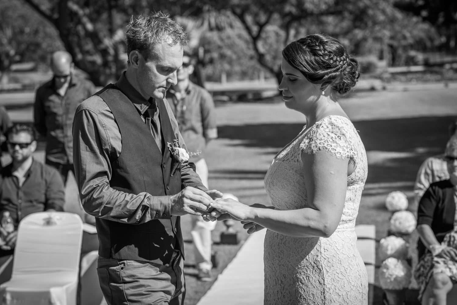 Groom putting ring on bride's finger