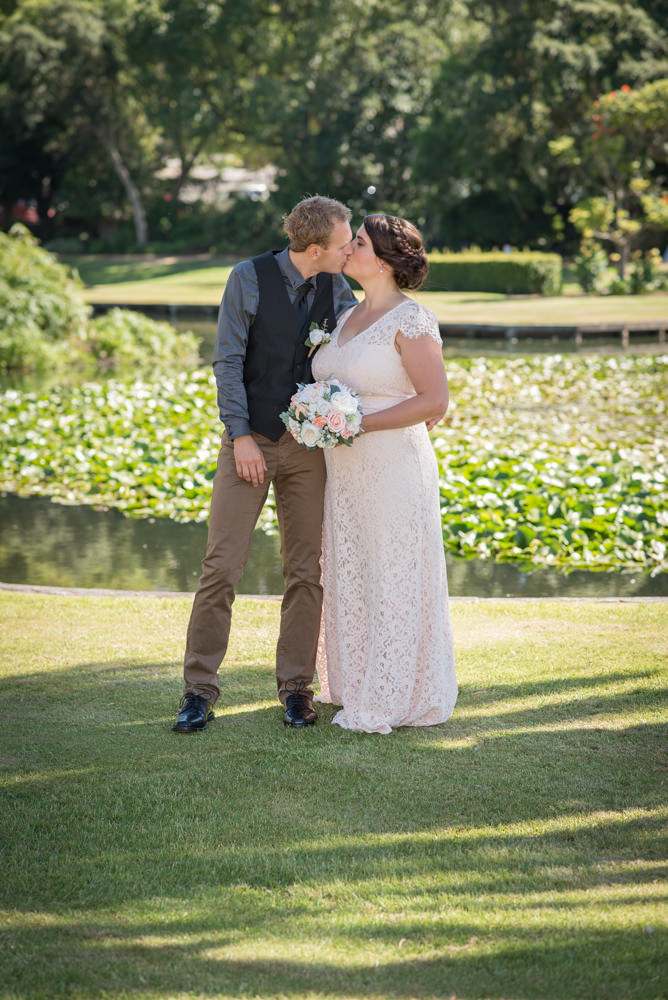 Bride and groom kissing in the Queen's gardens