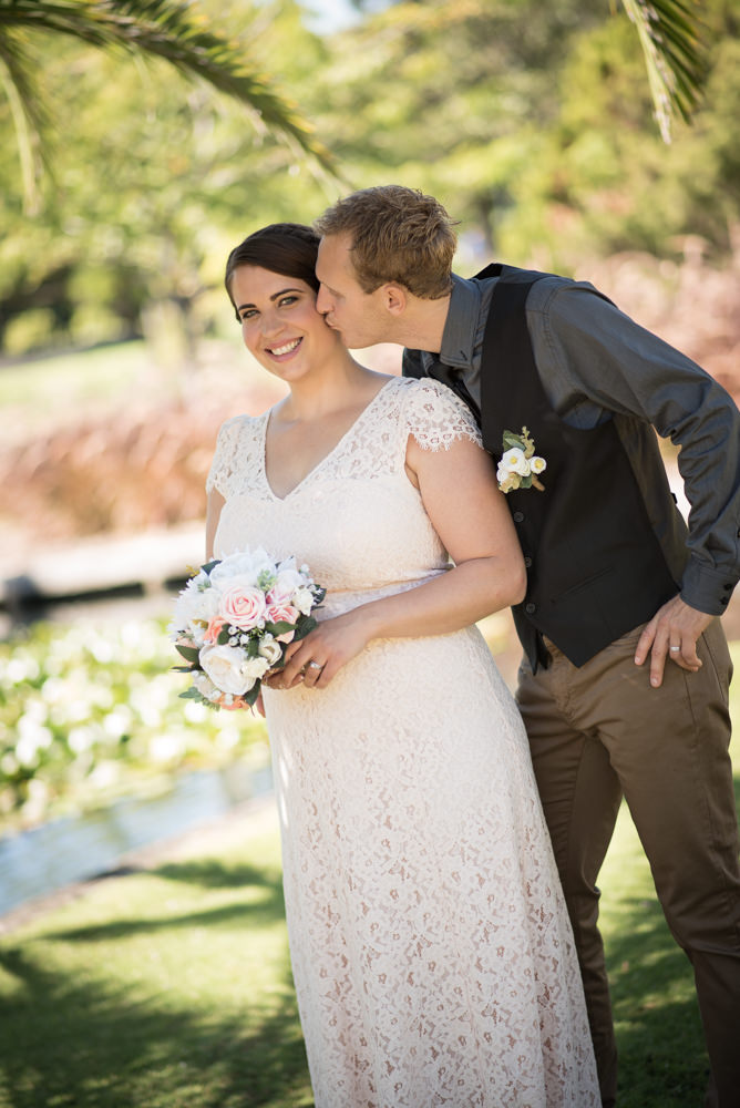 Groom kissing the bride on the cheek