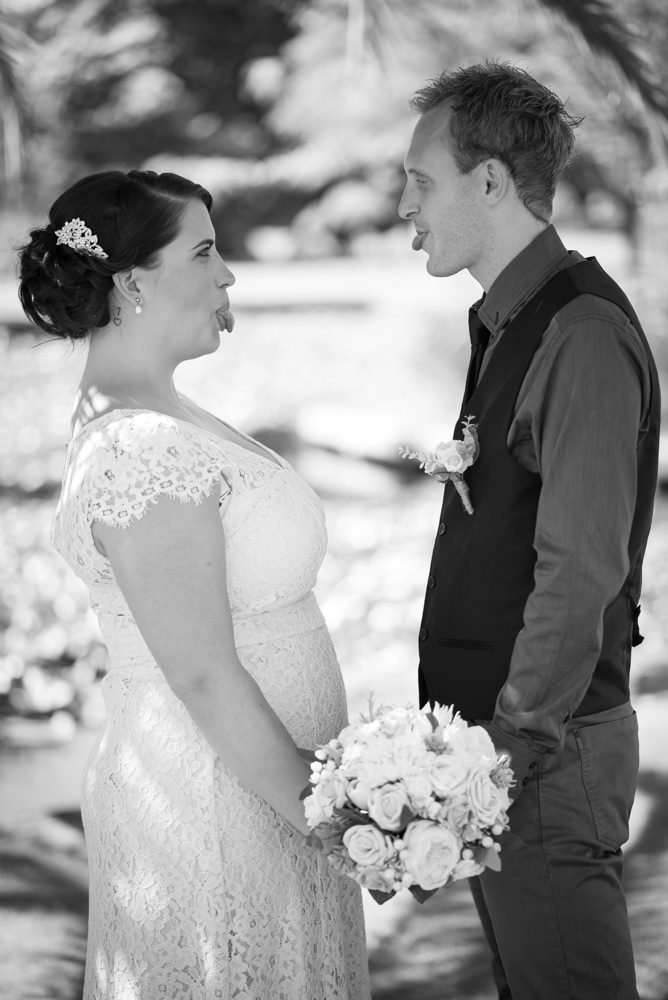 Bride and groom poking their tongues out at each other