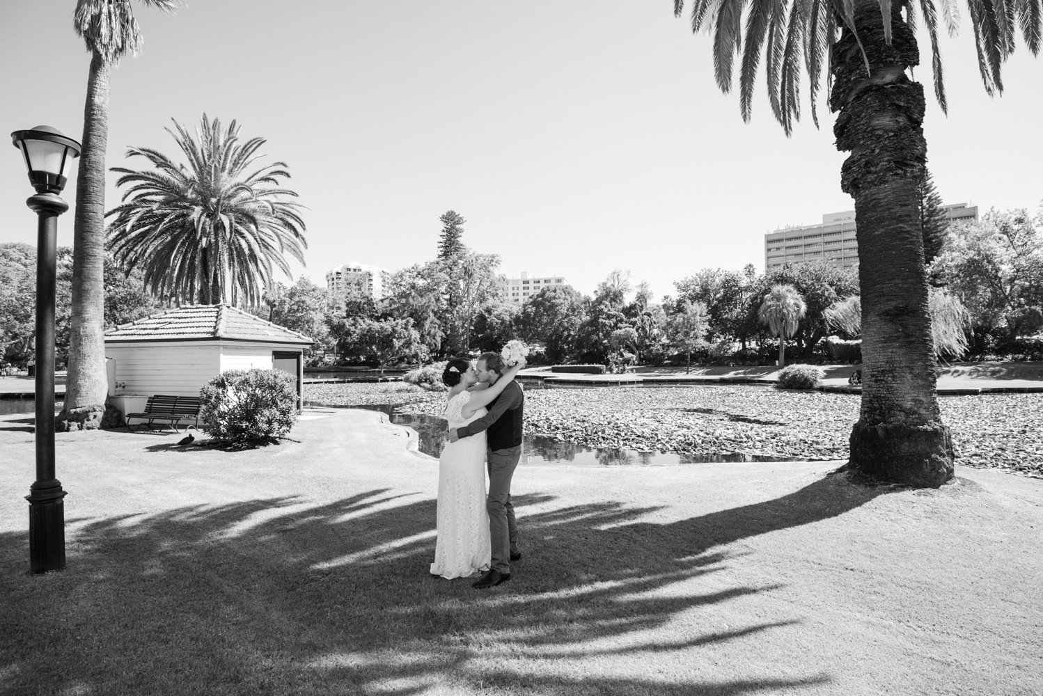 Black and white wide shot of wedding couple at Queens gardens