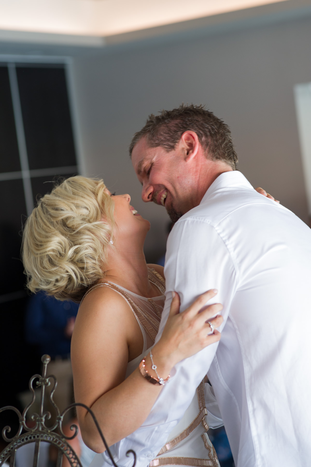 Bride and groom laugh after kissing