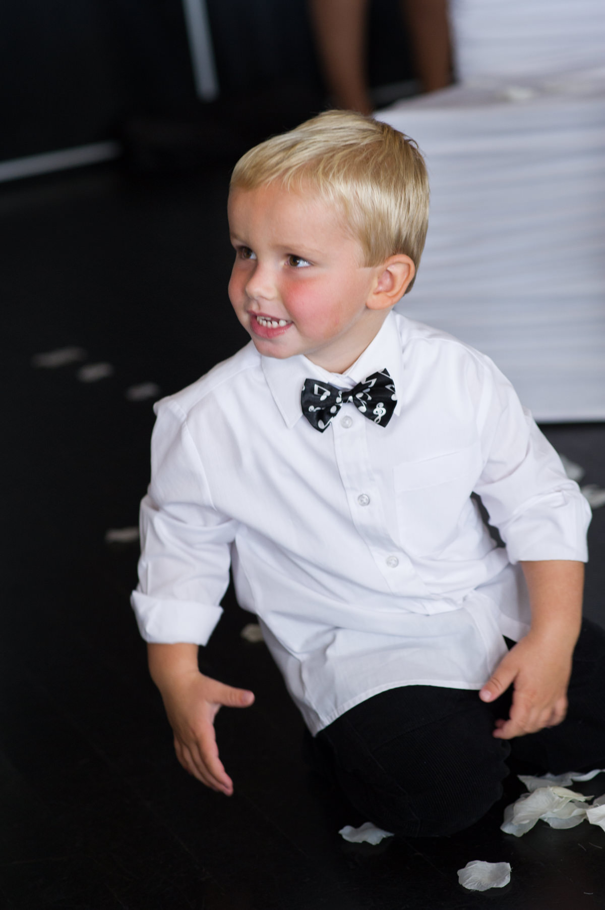 Little boy plays with rose petals on the floor