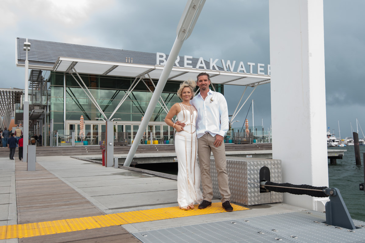 Bride and groom outside the Breakwater on a windy cloudy day