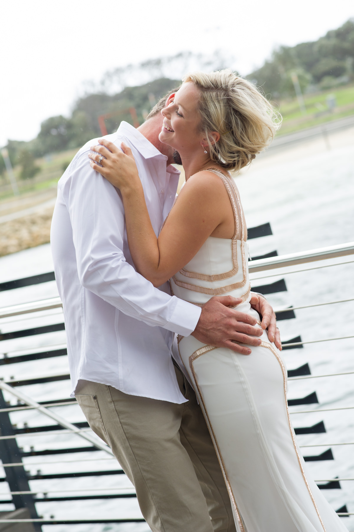 Groom kisses brides neck at the Breakwater