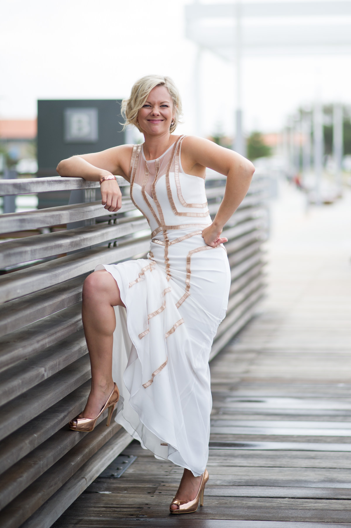 Bride puts her foot up on the fence at The Breakwater