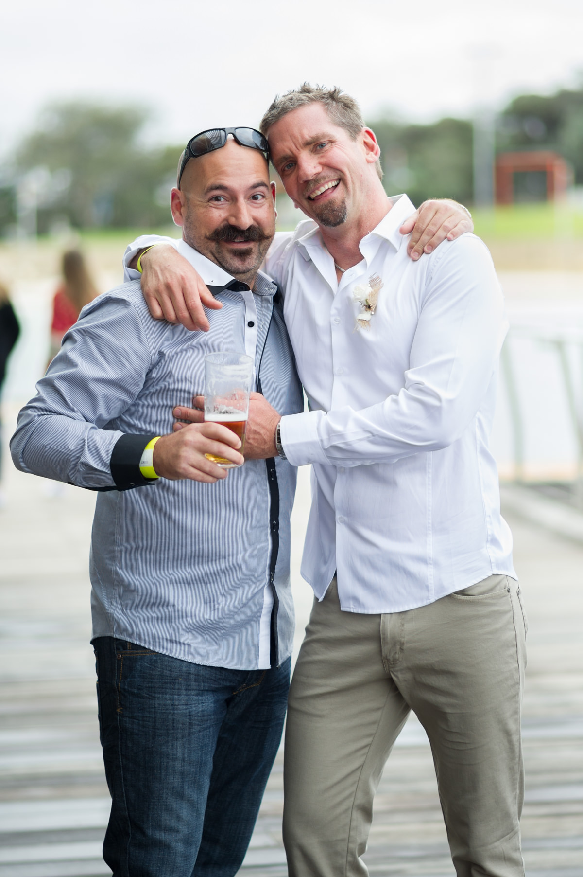 Grooms hugs his friend with a moustache